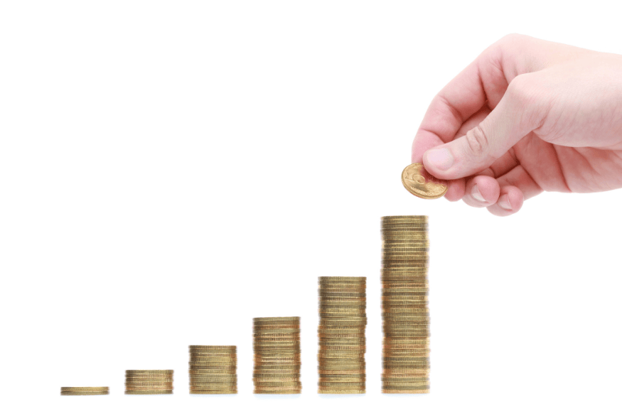 Hand stacking coins in ascending piles, illustrating compound interest growth and how APY can increase savings over time
