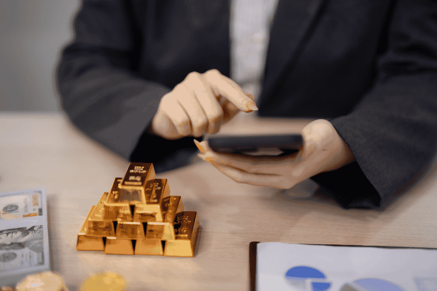 Investor reviewing gold bars and portfolio charts, representing diversification beyond stocks and bonds in asset allocation