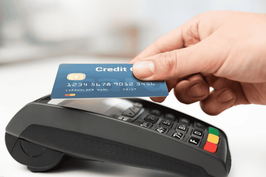 Hand inserting a credit card into a payment terminal for a contactless transaction.