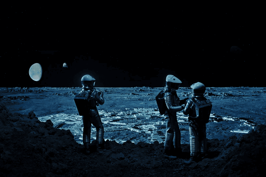 Cena do filme “2001: Uma Odisseia no Espaço” com astronautas em paisagem lunar fictícia