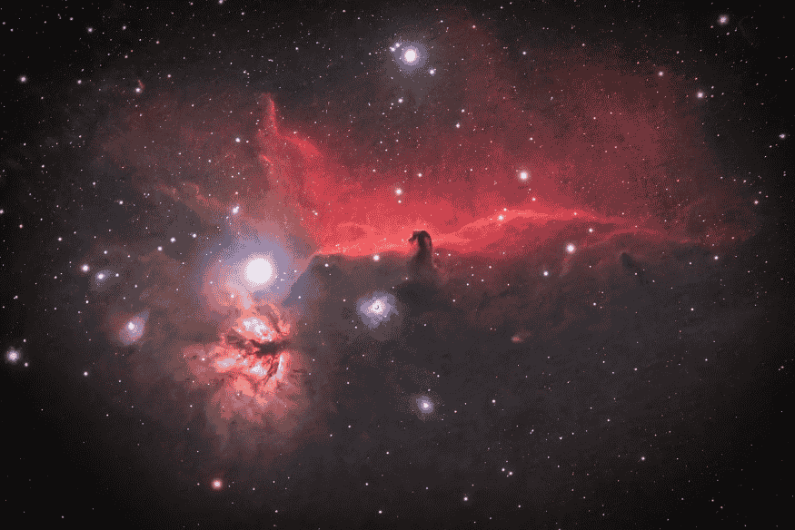 Imagem detalhada de nebulosa vermelha e estrelas no espaço, capturada com astrofotografia de céu profundo.