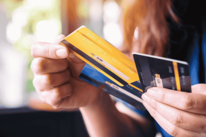 Person holding and comparing multiple credit cards in hand