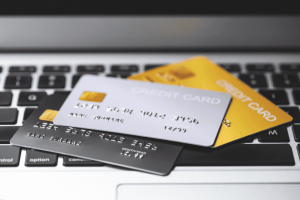Three credit cards placed on a laptop keyboard, representing online payment and financial options.