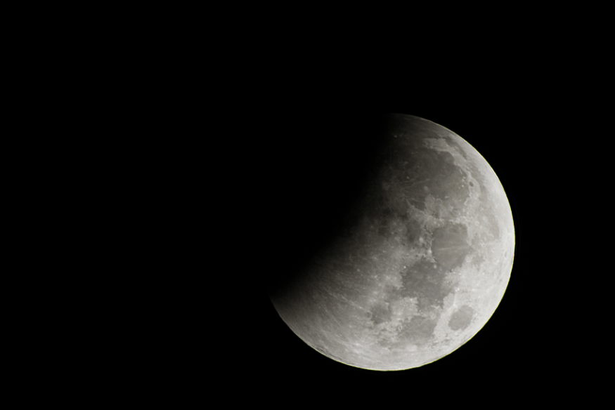 Imagem da Lua parcialmente encoberta pela sombra da Terra durante um eclipse lunar.