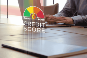 Businessperson using laptop with digital credit score indicator overlay showing good to poor scale.
