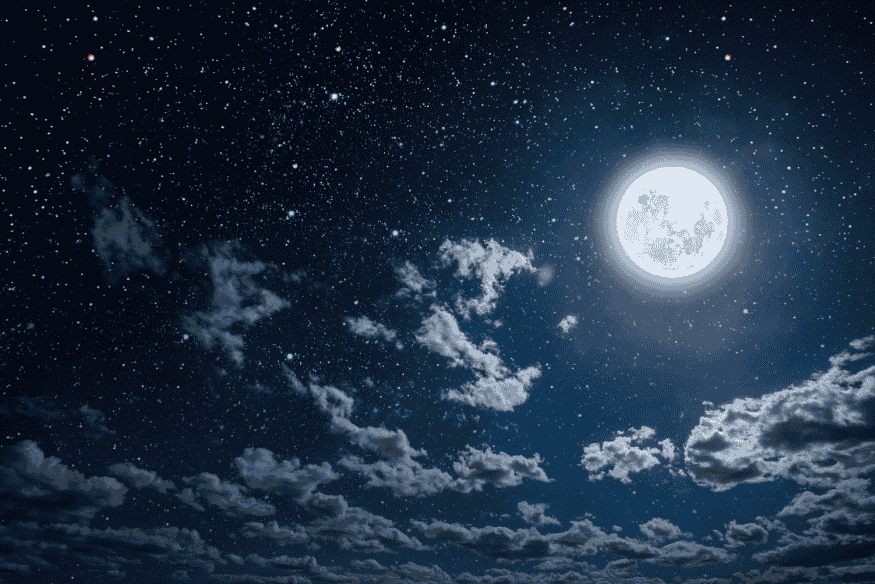 Lua cheia iluminando o céu estrelado com nuvens esparsas visíveis à noite.