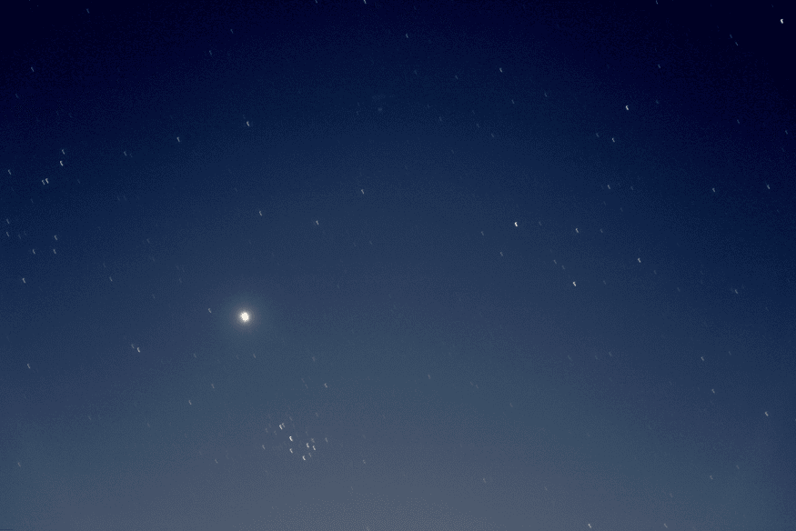 Planeta brilhante observado a olho nu em céu limpo, cercado por estrelas e constelações.