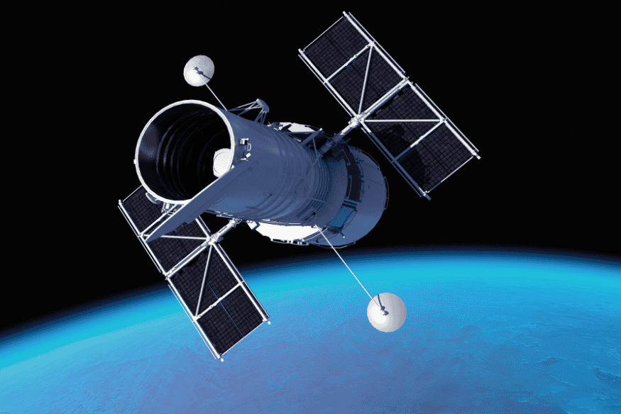 Telescópio espacial em órbita da Terra com painéis solares abertos.