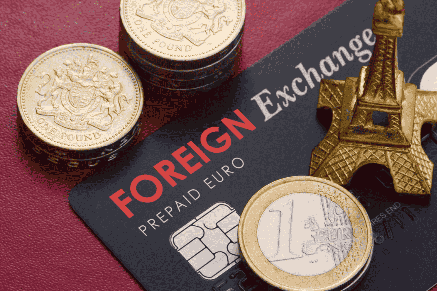 Foreign exchange card surrounded by euros, pounds, and a miniature Eiffel Tower