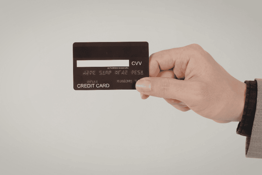 Hand holding a credit card close-up, symbolizing balance transfer eligibility, credit limits, and card terms